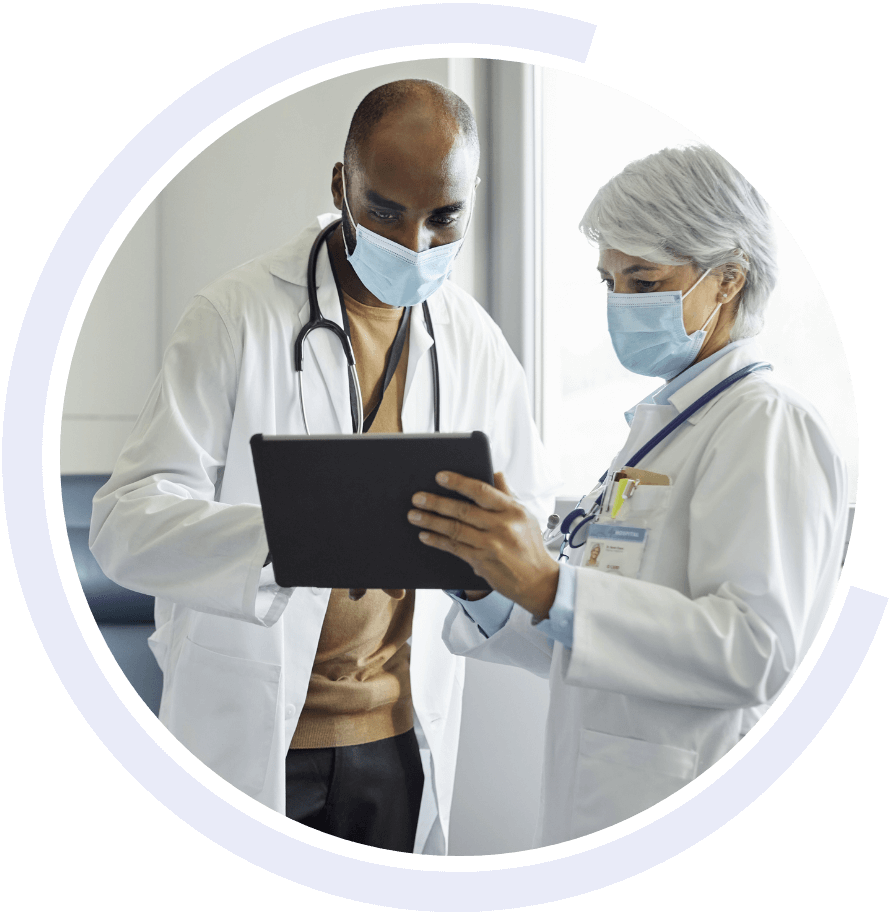 Two doctors holding a tablet while wearing masks Two doctors holding a tablet while wearing masks