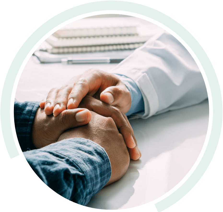 Doctor placing their hand over the folded hands of a patient Doctor placing their hand over the folded hands of a patient